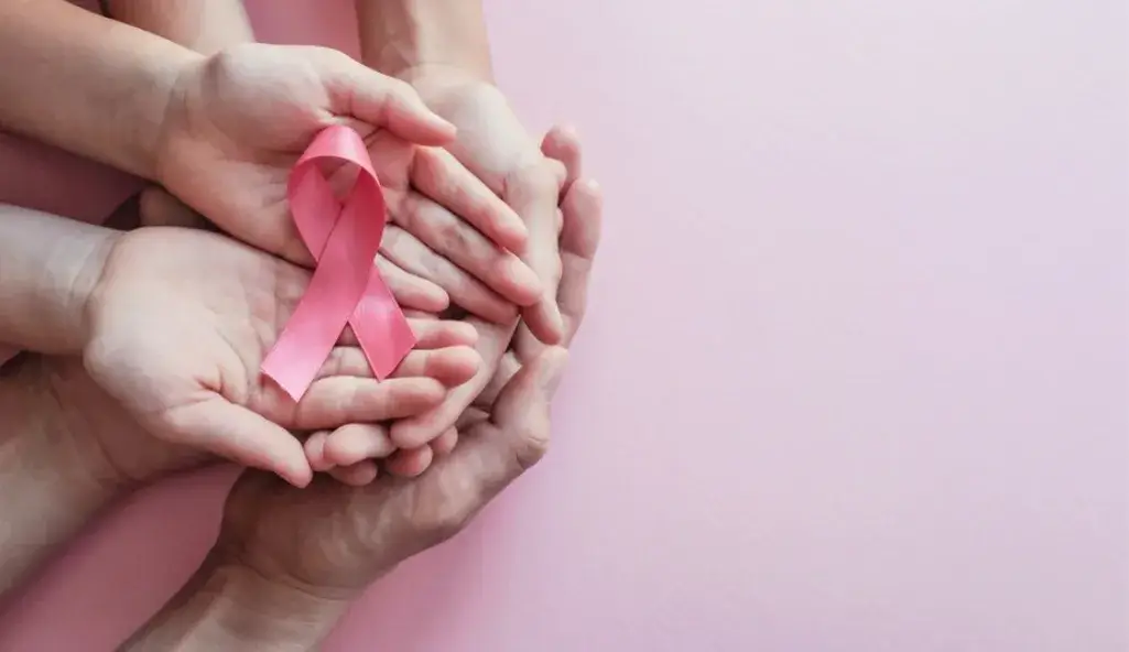 Hands holding a pink ribbon symbolizing breast cancer awareness – Excellent Cleaning supports October Pink.